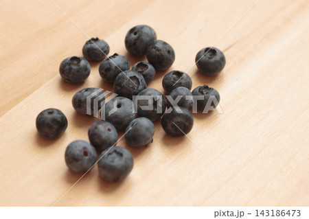 Fresh Blueberries Scattered on Light Wooden Table Surface Close Up 143186473