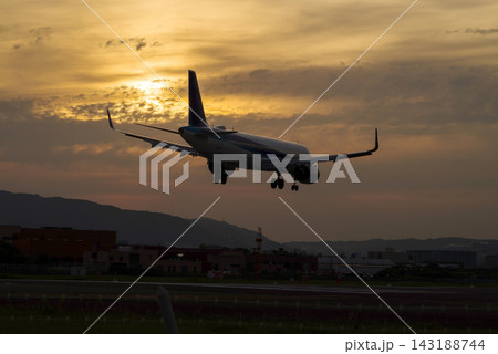 曇り空の夕暮れ、着陸態勢の小型ジェット旅客機 143188744