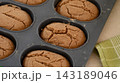 A close-up shot of freshly baked oval breads with cracked tops inside a silicone baking pan. 143189046