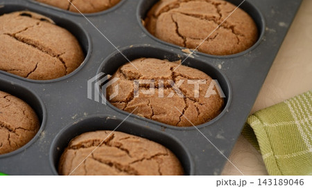 A close-up shot of freshly baked oval breads with cracked tops inside a silicone baking pan. A close-up shot of freshly baked oval breads with cracked tops inside a silicone baking pan. 143189046
