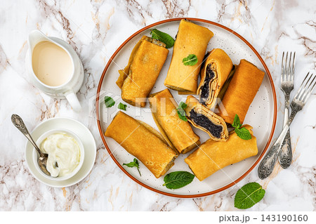 Rolled pancakes with poppy seed filling on plate Rolled pancakes with poppy seed filling on plate 143190160