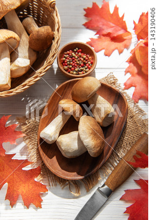 Porcini mushrooms harvest with red autumn leaves Porcini mushrooms harvest with red autumn leaves 143190406