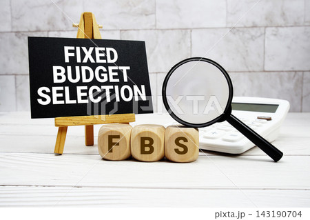 FBS Fixed Budget Selection text with calculator magnifying glass and on wooden background 143190704