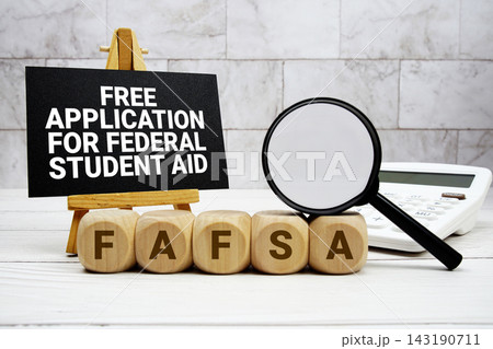 FAFSA Free Application for Federal Student Aid text with calculator magnifying glass and on wooden background FAFSA Free Application for Federal Student Aid text with calculator magnifying glass and on wooden background 143190711