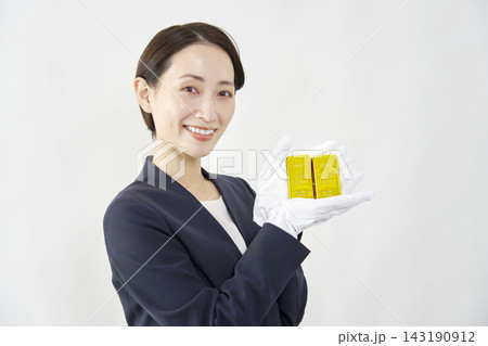 金塊を持つ女性鑑定士 白背景 金塊を持つ女性鑑定士 白背景 143190912