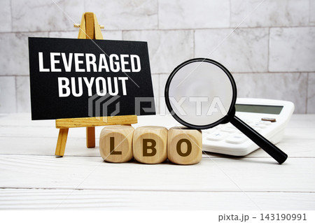 LBO Leveraged Buyout text with calculator magnifying glass and on wooden background 143190991