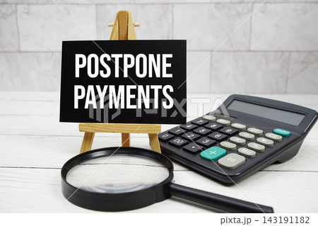 Postpone Payments text with calculator and magnifying glass 143191182