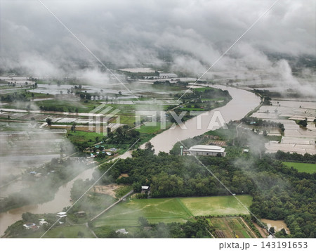 Mist blankets an aerial view of the swollen Khlong Yang canal overflowing into rural rice fields in Uthai Thani. Mist blankets an aerial view of the swollen Khlong Yang canal overflowing into rural rice fields in Uthai Thani. 143191653