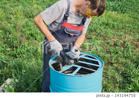 Man safety goggles and gloves, cutting metal for DIY upcycling project outdoors Man safety goggles and gloves, cutting metal for DIY upcycling project outdoors 143194758
