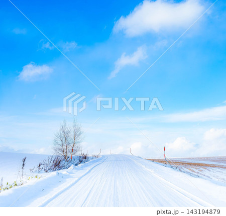 青空が広がる冬の北海道美瑛町の丘の上の圧雪になった雪道 青空が広がる冬の北海道美瑛町の丘の上の圧雪になった雪道 143194879