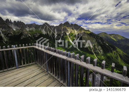 Mountain landscape with wooden viewing platform and dramatic peaks Mountain landscape with wooden viewing platform and dramatic peaks 143196670