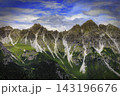 Mountain range with rugged peaks and green alpine slopes 143196676