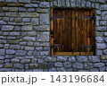 Rustic wooden shutter in a stone wall 143196684