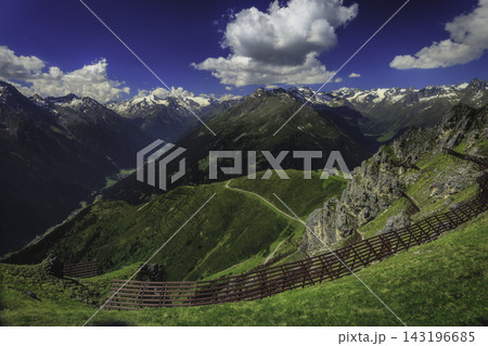 Alpine mountain valley beneath a dramatic sky 143196685