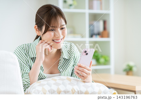 リビングでスマホを使う若い女性 リビングでスマホを使う若い女性 143196763