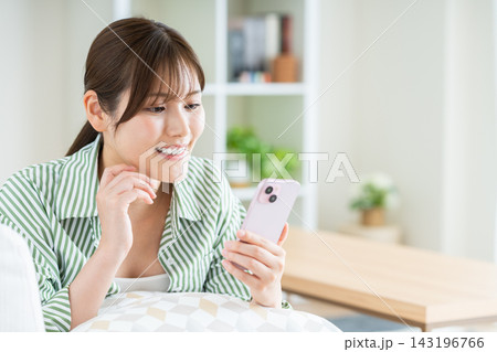 リビングでスマホを使う若い女性 リビングでスマホを使う若い女性 143196766