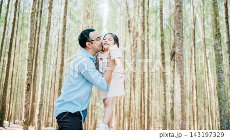 Playful family moment, father holds happy little girl up high, throwing up in sky at park forest. cheerful child enjoy moment playing freedom and joy Playful family moment, father holds happy little girl up high, throwing up in sky at park forest. cheerful child enjoy moment playing freedom and joy 143197329