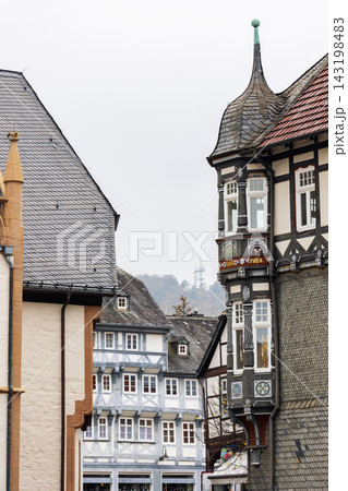 Historic Goslar center features ornate red facade, half timbered houses and autumn trees. Medieval architecture, decorative figures and colorful streetscape create charming German heritage atmosphere Historic Goslar center features ornate red facade, half timbered houses and autumn trees. Medieval architecture, decorative figures and colorful streetscape create charming German heritage atmosphere 143198483