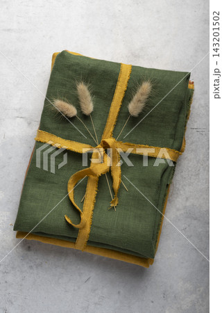 High angle view of a stack of folded green linen fabric High angle view of a stack of folded green linen fabric 143201502