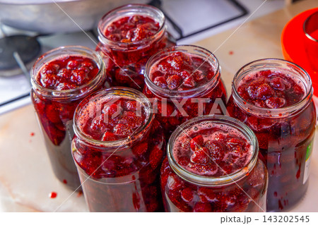Vibrant Strawberry Jam in Glass Jars on Countertop Vibrant Strawberry Jam in Glass Jars on Countertop 143202545