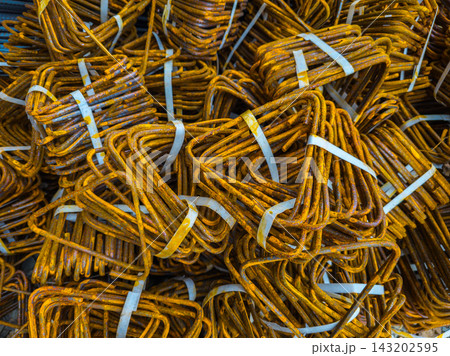 Close-Up of Rusty Steel Rebar Bundles Tied With Straps 143202595
