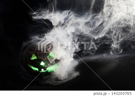 Halloween jack-o'-lantern glowing green with smoke 143203765