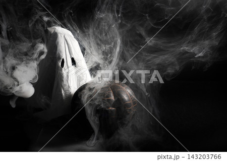 Ghost figure and pumpkin surrounded by swirling smoke Ghost figure and pumpkin surrounded by swirling smoke 143203766