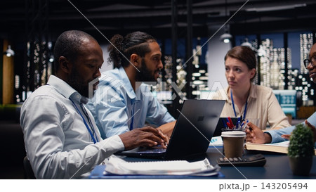 Business manager leading multiracial team, fostering teamwork and positive office culture. Management executive in boardroom supervising administrative staff, delegating tasks and reviewing KPIs. 143205494