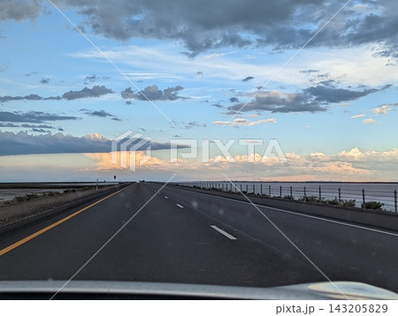 Driving on I-80 Away From Bonneville Salt Flats at Sunset with Stunning Skies Driving on I-80 Away From Bonneville Salt Flats at Sunset with Stunning Skies 143205829
