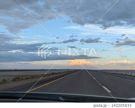 Driving on I-80 Away From Bonneville Salt Flats at Sunset with Stunning Skies 143205833