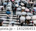 傘をさして交差点を渡る歩行者　大阪の梅田 143206453