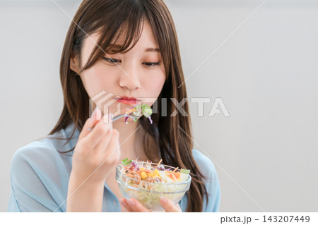 家でサラダを食べる野菜嫌いな若いアジア人女性(好き嫌い,困る,悩む) 家でサラダを食べる野菜嫌いな若いアジア人女性(好き嫌い,困る,悩む) 143207449
