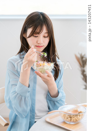 家でサラダを食べる野菜嫌いな若いアジア人女性（好き嫌い,困る,悩む） 143207451