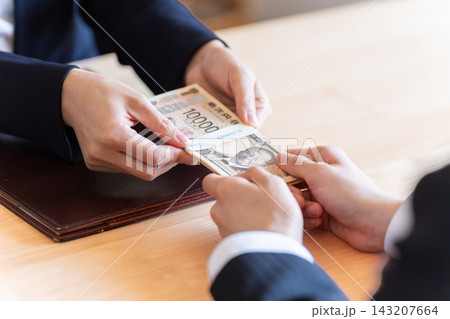 お金を渡すビジネスマン お金を渡すビジネスマン 143207664