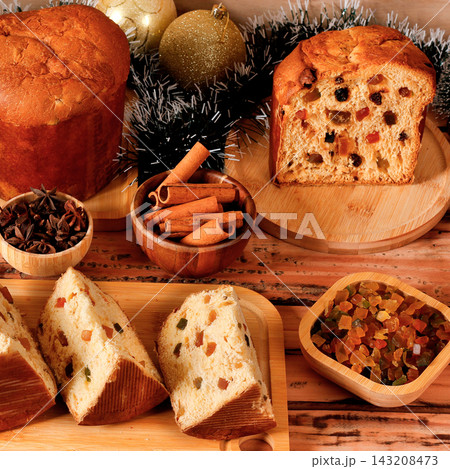 Traditional Christmas panettone with candied fruit and raisins, sliced, in a Christmas party setting. 143208473
