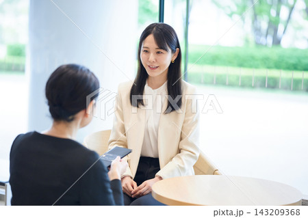 ラウンジで決済時にスタッフと会話する女性 ラウンジで決済時にスタッフと会話する女性 143209368