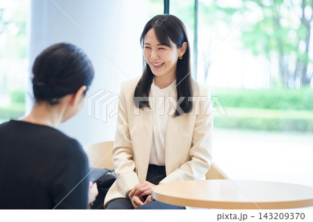 ラウンジで決済時にスタッフと会話する女性 ラウンジで決済時にスタッフと会話する女性 143209370