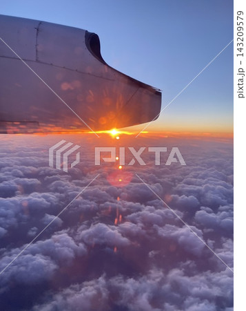 夕日に染まる雲海と飛行機の機窓から望む北海道の空 夕日に染まる雲海と飛行機の機窓から望む北海道の空 143209579