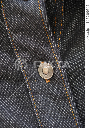 Close-up of a button on a denim shirt in natural light Close-up of a button on a denim shirt in natural light 143209641