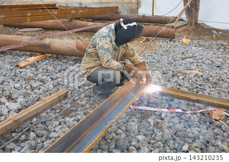Welder in mask welding metal construction on open air. 143210235