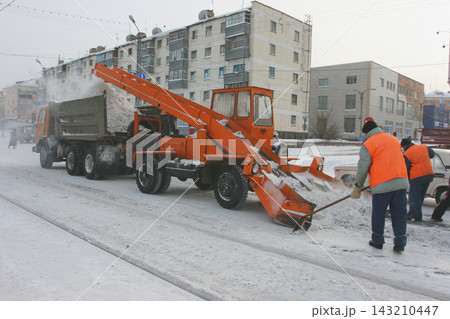 Yellow snowplow clearing a road during a snow storm Stock Photo 143210447