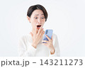 スマホを見て驚く女性 143211273