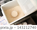 パントリーに置かれた米びつと計量カップに入った米 143212740