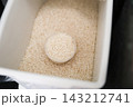 パントリーに置かれた米びつと計量カップに入った米 143212741
