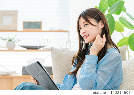 タブレットを操作して動画配信を見る,情報収集をする女性 タブレットを操作して動画配信を見る,情報収集をする女性 143214607