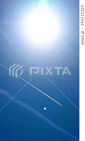 太陽の光が差し込む青空のもと、月とまっすぐに伸びる飛行機雲が奇跡的なバランスで共演 太陽の光が差し込む青空のもと、月とまっすぐに伸びる飛行機雲が奇跡的なバランスで共演 143215325