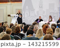 Conference audience facing speakers during a panel discussion 143215599