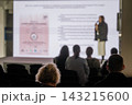 Audience silhouettes against an illuminated presentation screen 143215600
