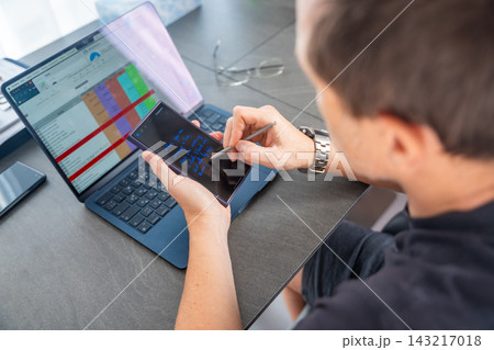 Close up view of man hand holding smart phone and stylus pen at his creative workspace.  143217018