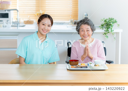 食事の介助をするヘルパーとシニア女性 143220922